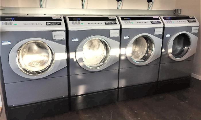 Vier professionele wasmachines op sokkels